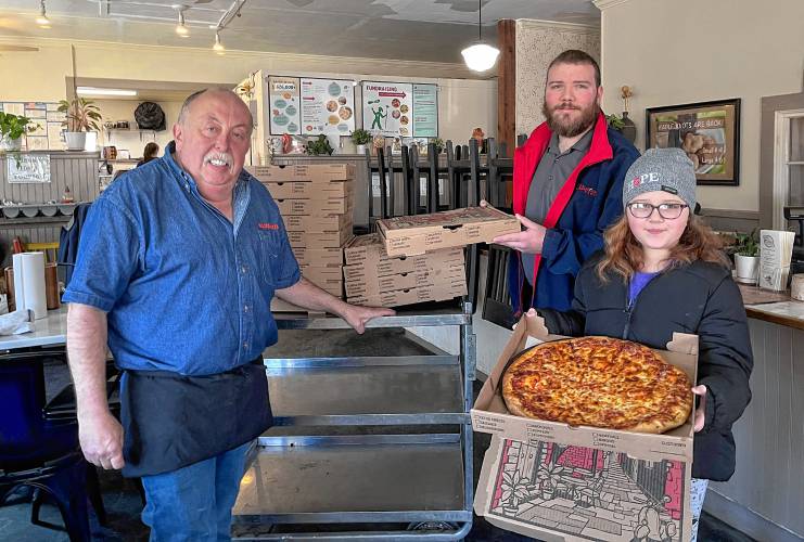 Craig White of Hillside Pizza in Bernardston with Lt. Paul Leslie of the Greenfield Salvation Army and his daughter Abigail with donated pizzas for community meals.