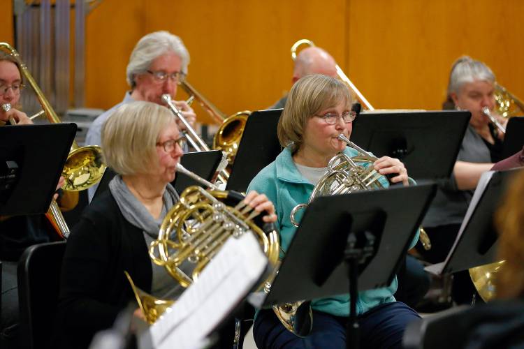 Bombyx Brass Collective french horn players Shelly Brezinsky, left, and Jody Kinner run through music with the South Hadley High School band during class Tuesday morning at the high school.