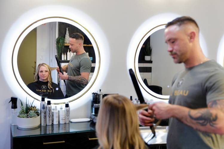 Owner and senior stylist Justin Foucher, right, works on fellow stylist Ashley LaRochelle’s hair on Tuesday at Le Beau Salon in Northampton.
