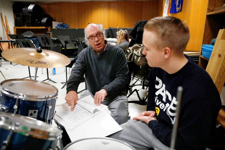 Bombyx Brass Collective percussionist David Choquette, left, talks through music with Griffin Blackburn while visiting the South Hadley High School band class Tuesday morning at the high school.