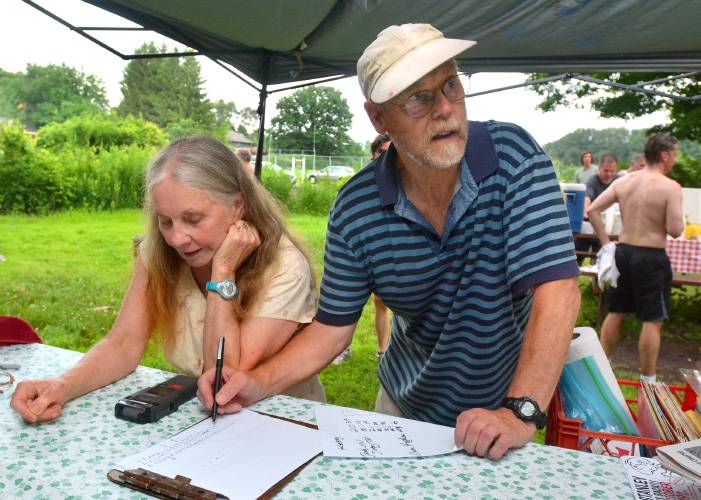 Sue and Don Grant record results during a past Sugarloaf Mountain Athletic Club 5-K race at Northampton Community Gardens. 
