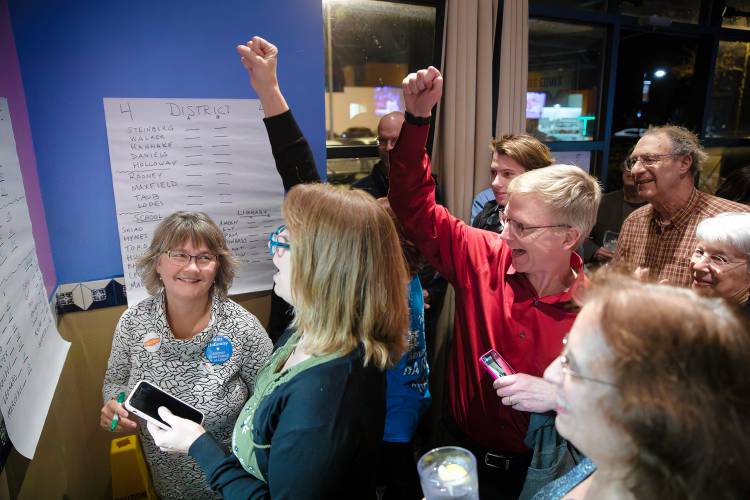 Clare Bertrand, from left, Kursten Holabird and Peter Demling react after tallying election numbers Tuesday night during a gathering at Garcia’s Restaurant in Amherst.