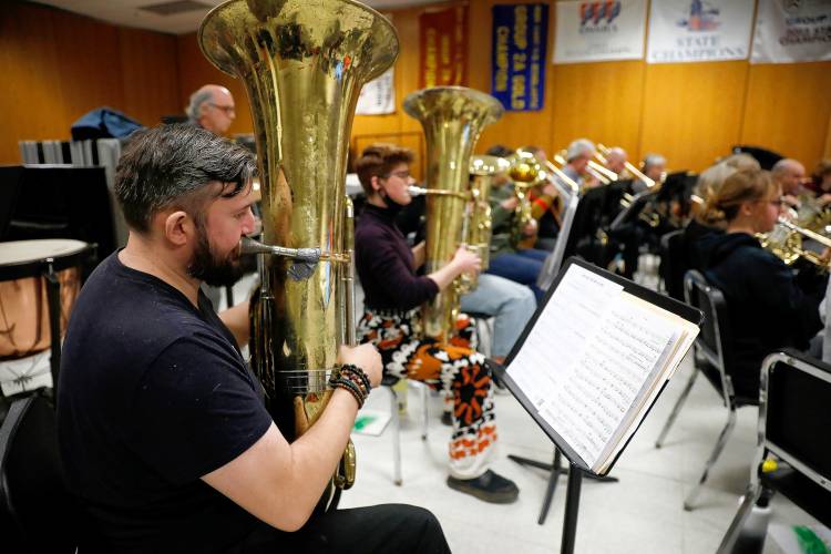 Bombyx Brass Collective tuba player Jay Witbeck runs through music with Kailtin Blasko and the South Hadley High School band during class Tuesday morning at the high school.