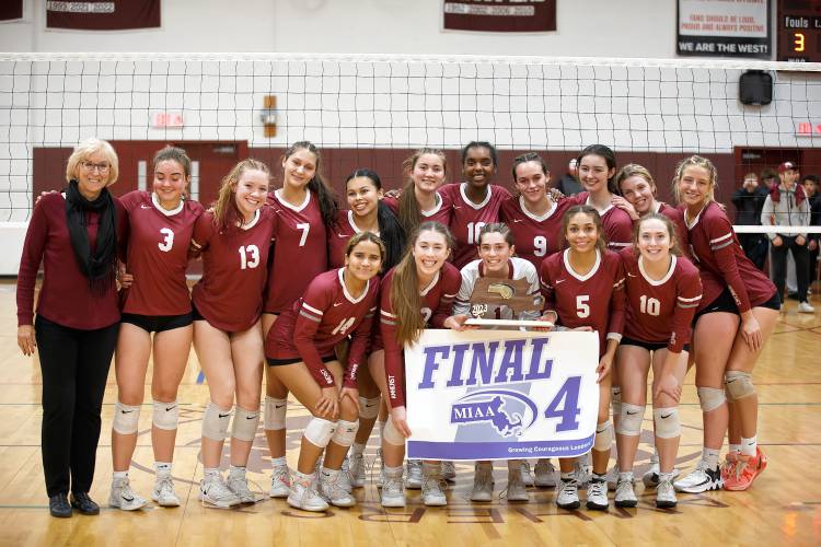Amherst poses for a team photo with the MIAA Division Division 3 Final Four plaque and banner after defeating Holliston on Thursday in Amherst.
