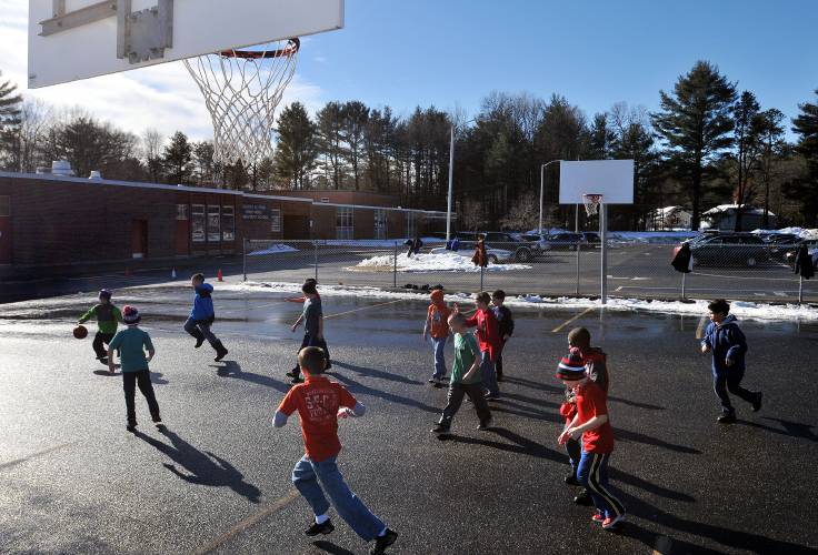 Students play basketball during the second and third grade noon recess at R.K. Finn Ryan Road School in Northampton.