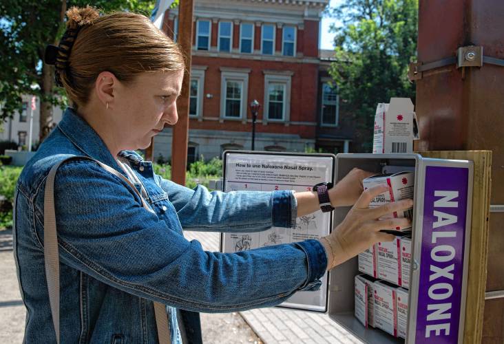Taylor McAndrew, the coordinator of Hampshire HOPE, refills one of two cabinets offering naloxone for free in Pulaski Park in Northampton on Sept. 6. The city is the first in Hampshire County to install the publicly accessible cabinets.
