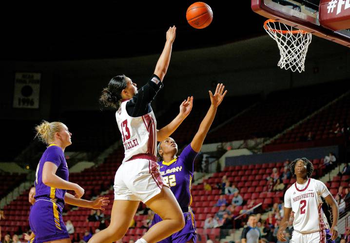 UMass forward Lilly Taulelei (33) drives to the hoop over Albany defender Deja Evans (22) in the third quarter Wednesday at the Mullins Center in Amherst.