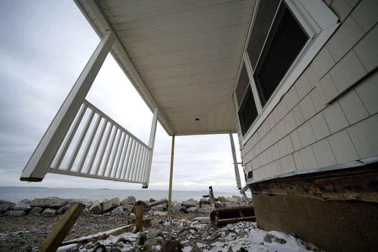 Posts and a railing are all that remain of a deck, Wednesday, Jan. 31, 2024, on a home in the Camp Ellis neighborhood of Saco, Maine. It is one of many waterfront buildings damaged by recent coastal storms.