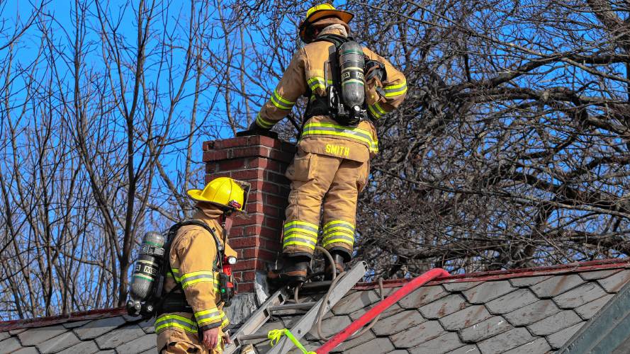 Firefighters examine the chimney of the house located on 7 Kingsley Ave. in Haydenville, where a fire broke out on Friday morning. No injuries were reported. 