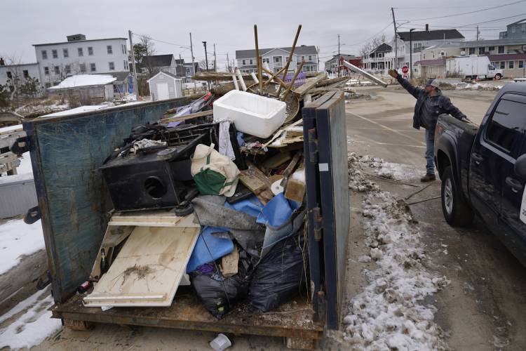 Property manager Brent Akmon dumps debris from waterfront property he has been repairing following a devastating storms, Wednesday, Jan. 31, 2024, in the Camp Ellis section of Saco, Maine.