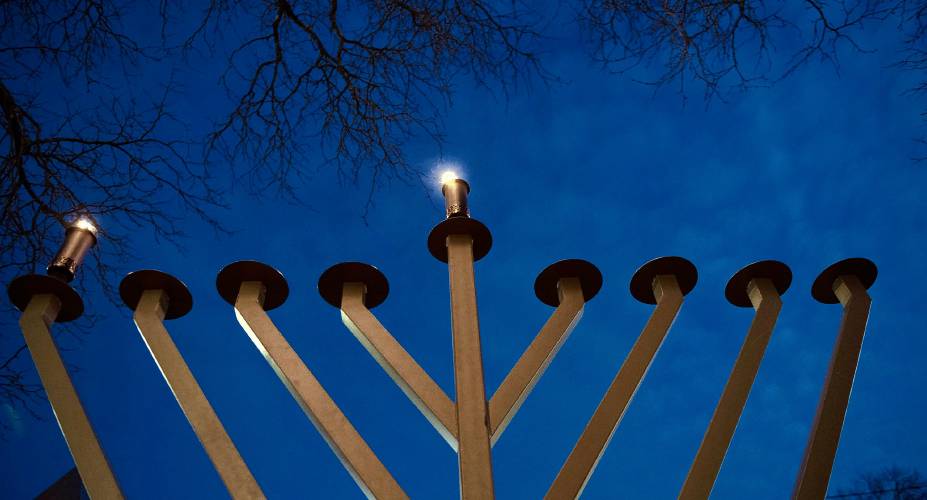 Community gathered with Rabbi Tuvia Helfen to celebrate and light the candles for the first day of Hanukkah.