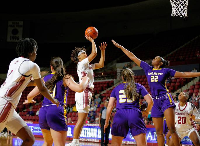 UMass guard Lilly Ferguson (4) puts up a shot in the paint over Albany defender Deja Evans (22) in the third quarter Wednesday at the Mullins Center in Amherst.