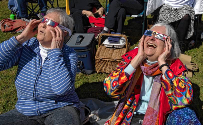 Sandy Lillydahl and June Gaeke ooh and aah while watching the  eclipse at the UMass Sunwheel on Monday afternoon. 