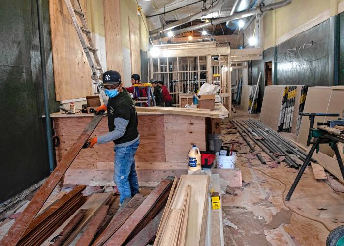 Manuel Loja, an employee of Sunwood Builders, works in the main entrance and new bar space of the Iron Horse in Northampton in late March.