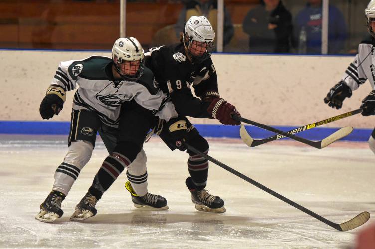 Amherst’s Cooper Beckwith (9), right, battles for the puck with Greenfield’s Jack Laurie (4) during the visiting Hurricanes’ 3-1 victory on Monday at Collins-Moylan Arena in Greenfield.