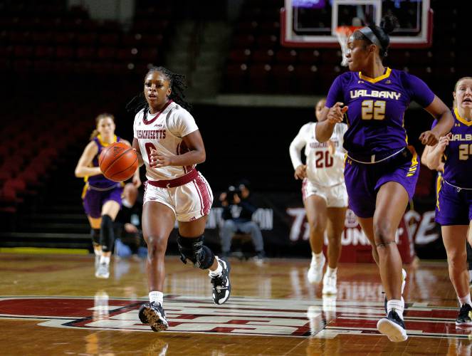 UMass guard Alexsia Rose (0) breaks down the court defended by UAlbany’s Deja Evans (22) in the fourth quarter Wednesday at the Mullins Center in Amherst.