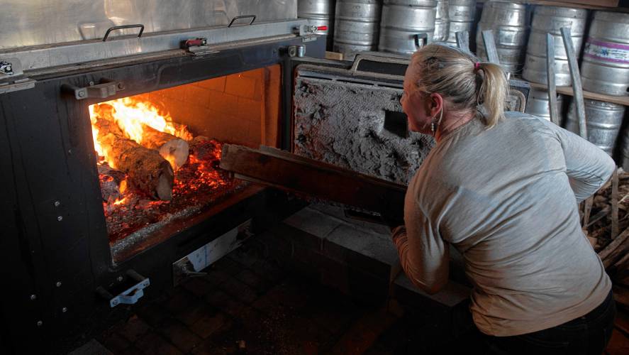 Amy Weber stokes the evaporator at Hickory Hill Farm in Worthington. “I love sugaring, I volunteer here so I can learn all I can,” Weber said.