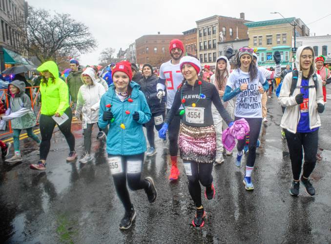 Fun run participants stride along Northampton’s Main Street during the 20th annual Hot Chocolate Run on Sunday to raise money for Safe Passage’s mission to provide support and services to survivors of domestic violence.