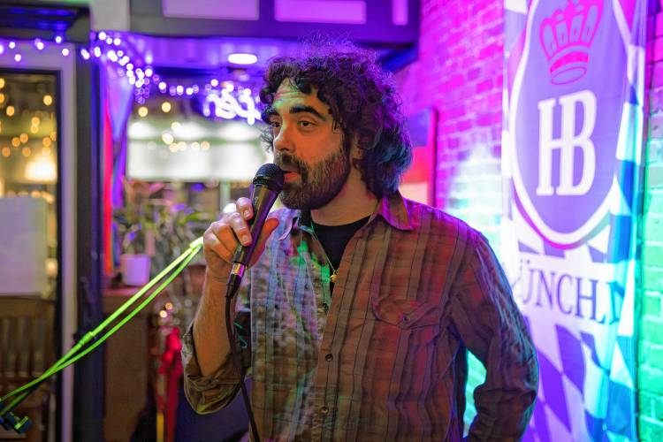 Host Tobey Sol LaRoche introduces the next act during open mic night at Wurst Haus in Northampton. A singer, songwriter, and drummer himself, LaRoche says he loves the variety of music that can be heard at open mics.