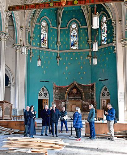 U.S. District Court Judge Mark G. Mastroianni, center, views the interior of St. Mary of the Assumption Church in Northampton. The Roman Catholic Diocese of Springfield has filed a lawsuit against Northampton over a stop-work order to halt the removal of stained-glass windows from the property. The church is trying to sell the property.