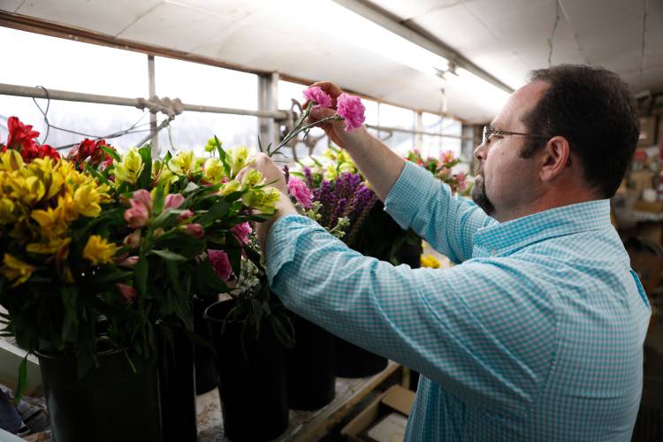 Seth Carey, fourth-generation owner of Carey’s Flowers, works on an arrangement last Thursday afternoon at the store in South Hadley.