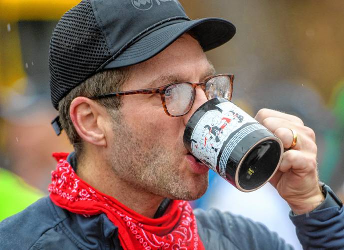 Robert Roose of Amherst sips hot chocolate after finishing the 20th annual Hot Chocolate Run in Northampton on Sunday to raise money for Safe Passage’s mission to provide support and services to survivors of domestic violence.