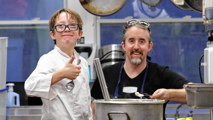  Oliver Hoyt, 10, with his father Colin helpin prepare meals for Manna Soup Kitchen’s Thanksgiving meal. More than 100 people volunteered to make the dinner possible, working multiple days to prepare, package and serve the meals.