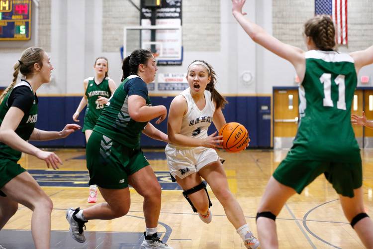 Northampton’s Bri Heafey (5) drives to the hoop through Mansfield defenders Kelsey O’Connor (3), Kara Santos (12) and Keira Fitzpatrick (11) in the fourth quarter of the MIAA Division 2 girls basketball Round of 16 game Tuesday night in Northampton.