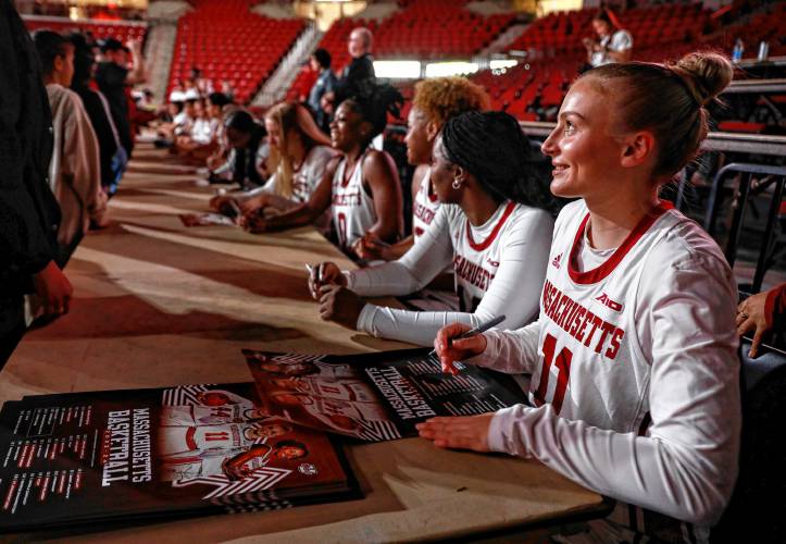 UMass women’s basketball players sign posters during the Mullins Madness event Thursday night at the Mullins Center in Amherst.