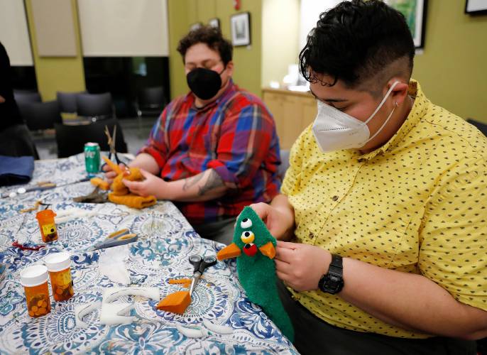 Ana Ascencio, right, and Evan Delano work on their puppet creations during a deluxe sock puppet class by Homeslice Puppetry on Thursday night at the South Hadley Public Library. 