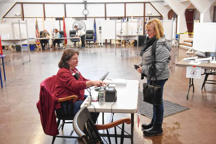 Deerfield election worker Julie Cavacco checks resident Barbara Miskemen in to vote in the Deerfield election on Tuesday. 