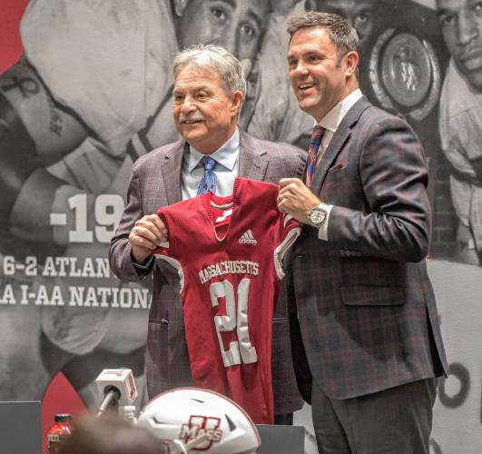 UMass football coach Don Brown, left, is presented a Minuteman jersey by UMass Director of Athletics Ryan Bamford during a press conference at his introduction in the Martin Jacobson Football Performance Center on Dec. 1, 2021.