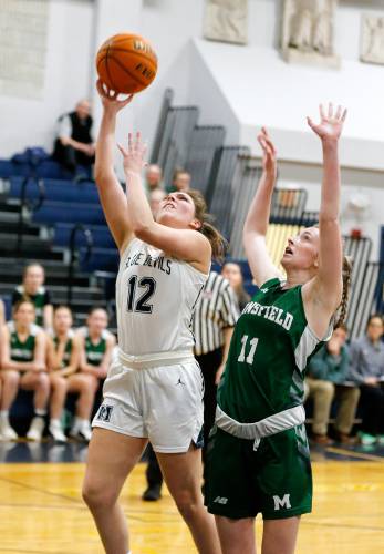 Northampton’s Chloe Derby (12) goes in for a breakaway layup past Mansfield defender Keira Fitzpatrick (11) in the second quarter of the MIAA Division 2 girls basketball round of 16 game Tuesday night in Northampton.