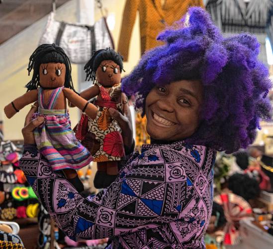 Aimee Salmon, owner of Positively Africana in Thornes Marketplace in Northampton, holds two of the many dolls she sells in her shop.