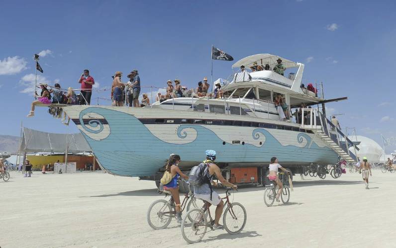 An old wooden yacht art car rolls through the playa at Burning Man on the Black Rock Desert, Friday Aug. 31, 2012, near Gerlach, Nev. Burning Man organizers don't foresee major changes in 2024 thanks to a hard-won passing grade for cleaning up this year's festival. 