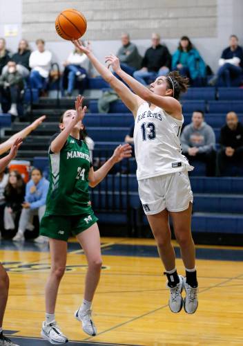 Northampton’s Ava Azzaro (13), right, puts up a shot from the baseline over Mansfield’s Ella Palanza (24) in the third quarter of the MIAA Division 2 girls basketball round of 16 game Tuesday night in Northampton.