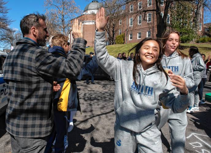 Ally Yamada, a member of the Smith College basketball team, gets a high-five from  Scott Johnson during a send-off on Tuesday. The team will play in the semifinals of the NCAA Division III Final Four on Thursday in Ohio.