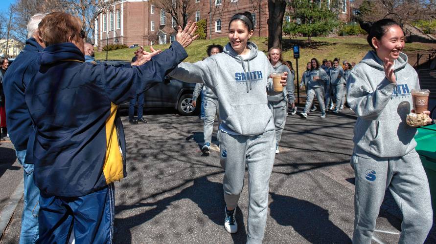 Sofia Rosa, a member of the Smith College basketball team, gets a high-five from Jerry and  Erika Herring during a send-off on Tuesday. The team will play in the semifinals of the NCAA Division III Final Four on Thursday in Ohio. 