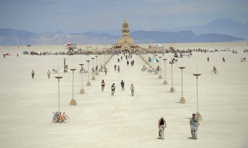 FILE - People walk toward the temple at Burning Man near Gerlach, Nev., on the Black Rock Desert, Friday, Aug. 31, 2012. Burning Man organizers don't foresee major changes in 2024 thanks to a hard-won passing grade for cleaning up this year's festival. Some question whether it has veered too far from its core principles of radical inclusion and participation. (Andy Barron/The Reno Gazette-Journal via AP, File)