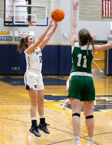Northampton’s Chloe Derby (12) takes a three-point shot over Mansfield defender Keira Fitzpatrick (11) in the third quarter of the MIAA Division 2 girls basketball round of 16 game Tuesday night in Northampton.