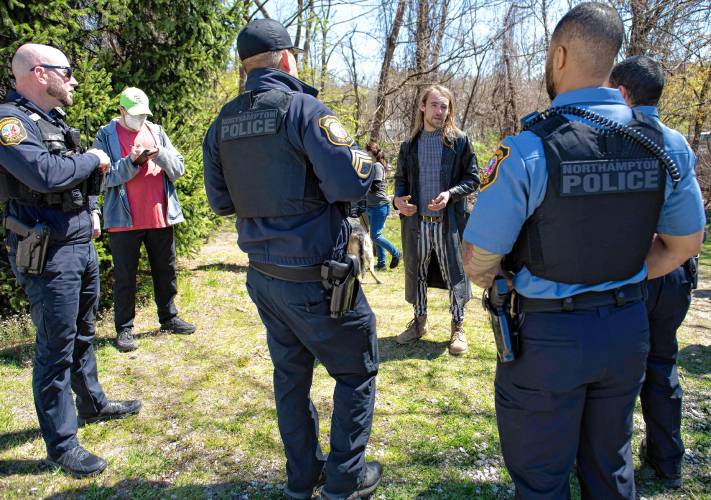 Ty, who would not give his last name and said he was a community action advocate, talks with Northampton police officers after  a homeless encampment off King Street was ordered to disperse by Monday.    