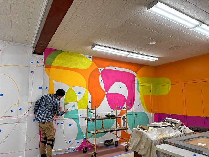Florence painter Sean Greene works on a mural for what’s now known as the Rainbow Room at the Bombyx Center in Florence.