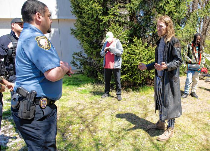 Ty, who would not give his last name and said he was a community action advocate, talks with Northampton police officers after  a homeless encampment off King Street was told they needed to disperse by Monday. The officers listened as Ty advocated for more warning when landowners request property to be vacated. 