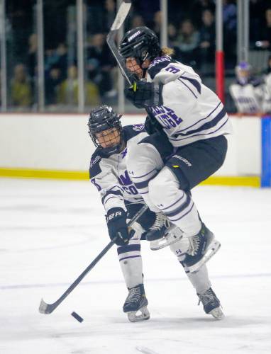 Amherst College’s Gretchen Dann (3) leaps to avoid interfering with a shot from Emily Hohmann (18) in the third period of the NESCAC women's hockey semifinal against Hamilton on Friday night at Orr Rink in Amherst.