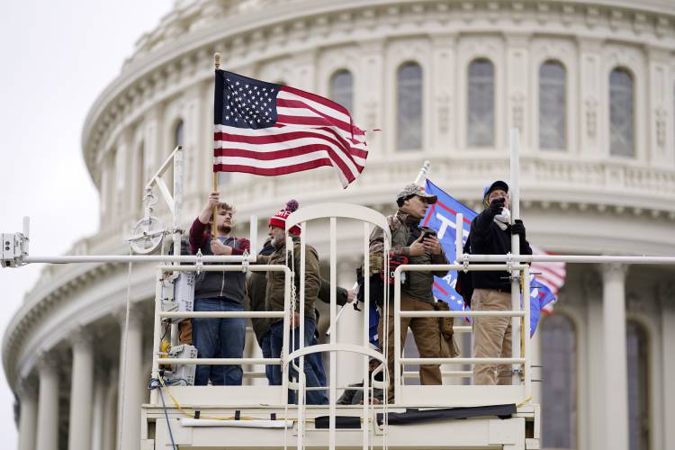 Supporters of President Donald Trump commandeer an elevated platform at the Capitol in Washington on Jan. 6, 2021.