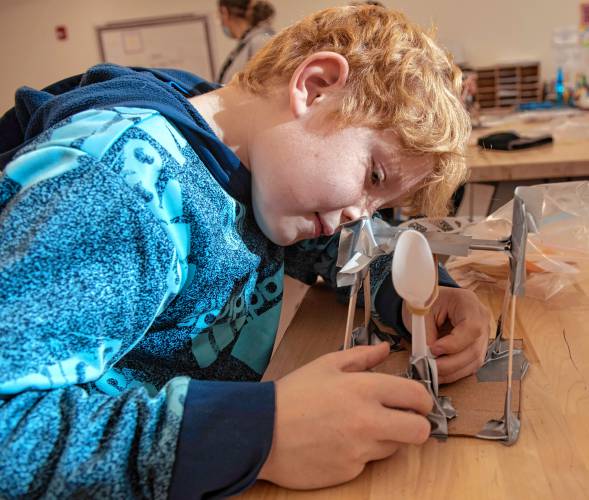 Finn Connelly, a fourth grader, works on the catapult he is building in the STEAM class with Megan Kelley Bagg at Mountain View School in Easthampton.