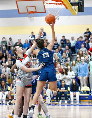 Northampton’s Ava Azzaro (13), right, puts in a layup past Worcester South defender Madi Leighton (13) in the third quarter of the MIAA Div. 2 girls basketball state semifinals Tuesday night at Chicopee Comp High School.