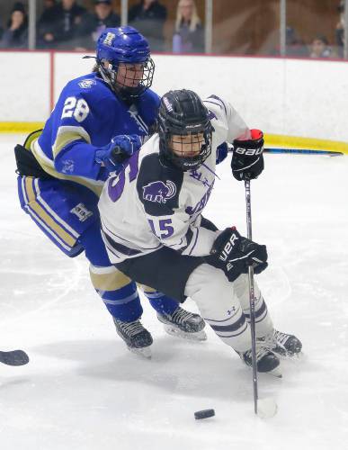 Amherst College’s Alyssa Xu (15) maneuvers the puck against Hamilton defender Sophie Berghammer (28) in the second period of the NESCAC women's hockey semifinals Friday night at Orr Rink in Amherst.