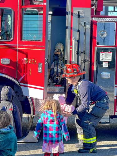 Northampton firefighters show their new ladder truck to some young onlookers during a practice they held earlier this month at the Bombyx Center in Florence.