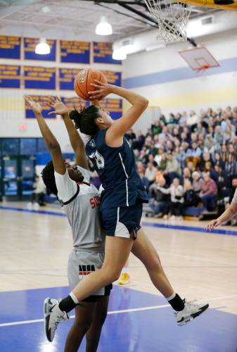 Northampton’s Ava Azzaro (13), left, jumps up for a shot over Worcester South defender Naima Bleou (5) in the second quarter of the MIAA Div. 2 girls basketball state semifinals Tuesday night at Chicopee Comp High School.
